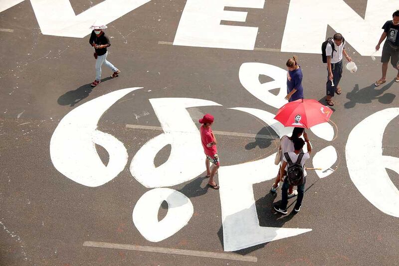 Protesters scale up their message on a street in downtown Yangon. (RFA)