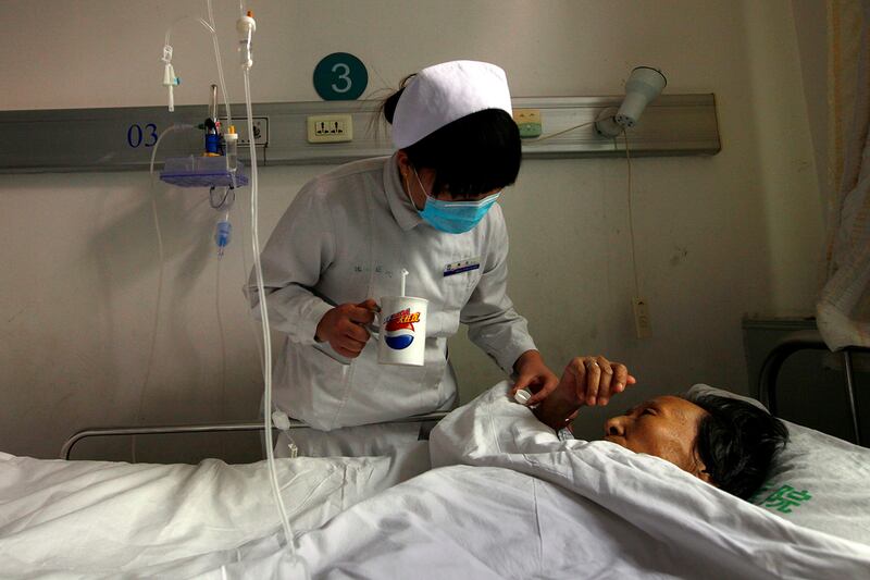 A nurse gives medicine to an HIV patient at the YouAn Hospital in Beijing, Dec. 1, 2011.