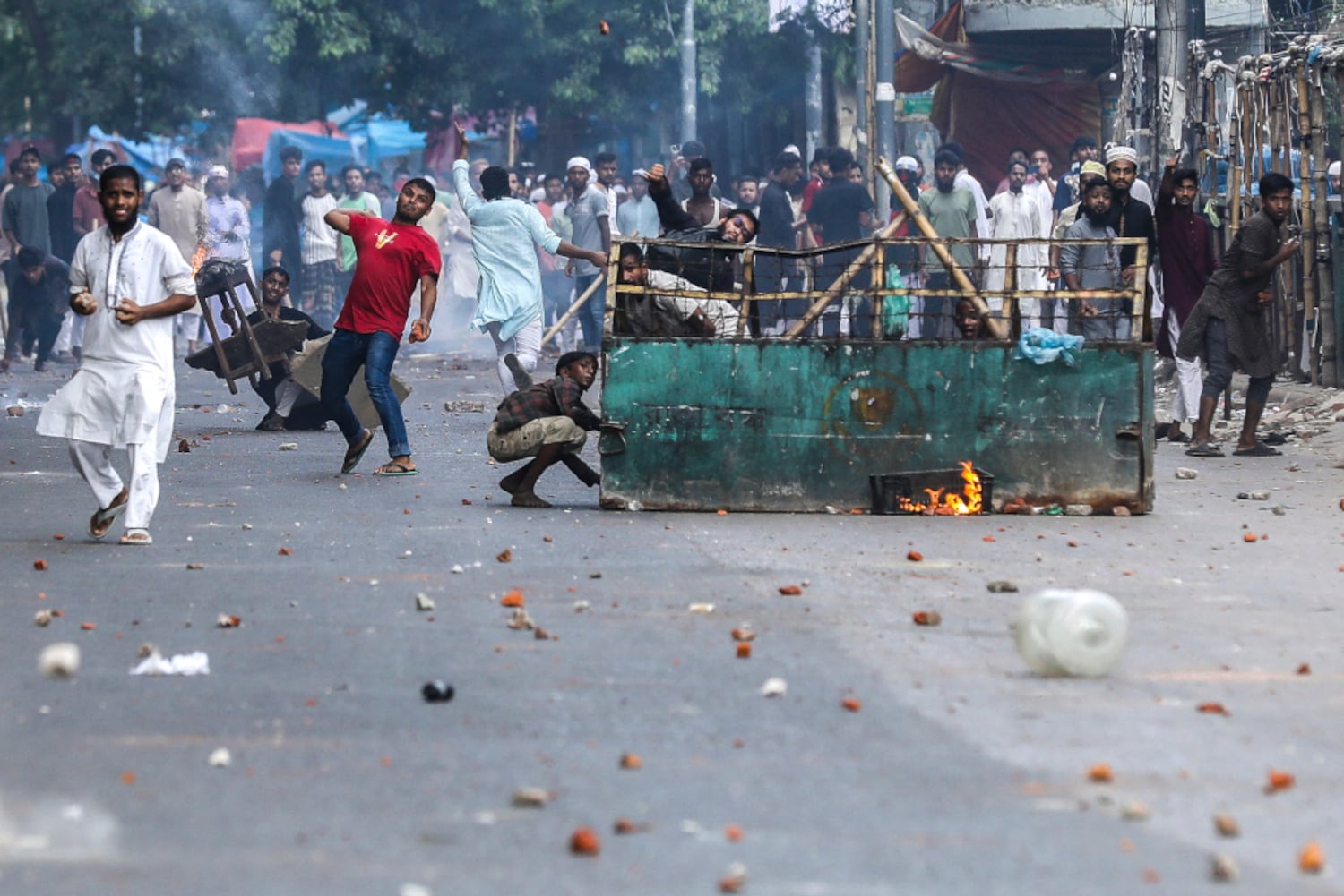 Demonstrators throw stones as they clash with police during the ongoing anti-quota protest in Dhaka, July 19, 2024. (Abu Sufian Jewel/AFP)