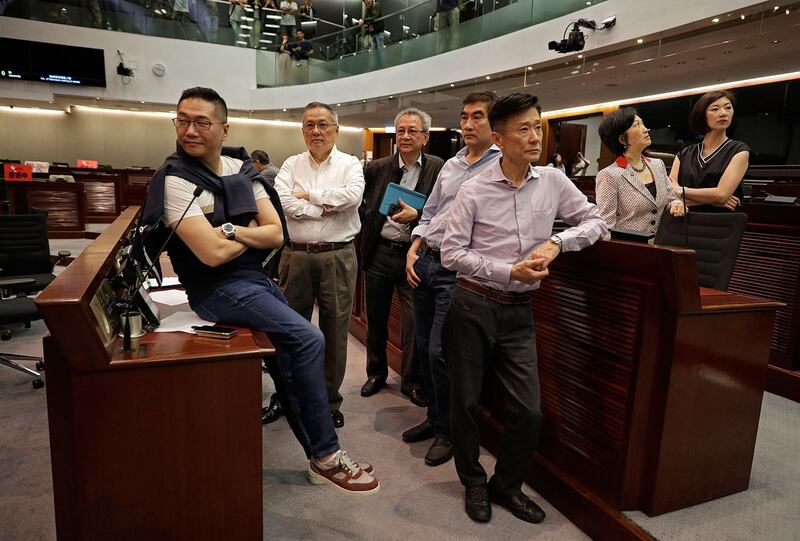 资料图片:2019年5月11日,香港民主建制两派议员就逃犯条例修订案在立法会发生冲突。图为亲北京的建制派议员在立法会上。(美联社)