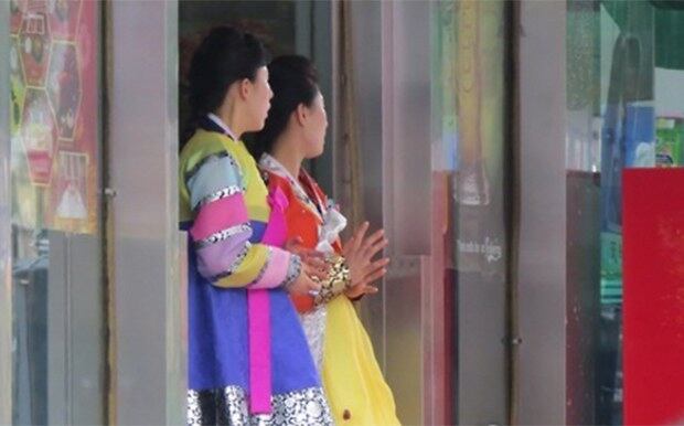 랴오닝성 선양의 한 북한식당 입구에서 손님맞이 대기 중인 여종업원의 모습.