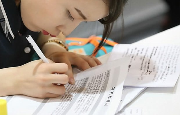 서울 강남구 코엑스에서 열린 2014 고졸성공 취업대박람회를 찾은 학생이 미리 적어 온 자기소개서를 옮겨 적고 있다.
