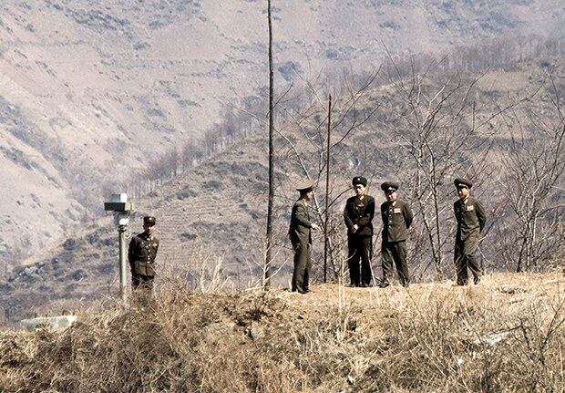 북한 군인들이 압록강변의 감시카메라 주변에서 대화를 나누고 있다.