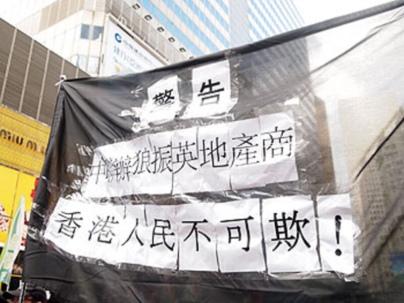2012年7月1日，香港市民高舉抗議官商勾結橫額參與七一遊行，表示香港人不會受蒙騙。（粵語部林靜攝）