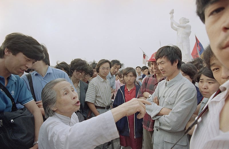 1989年5月31日,一位老人在天安门广场上跟学生讨论。(美联社)