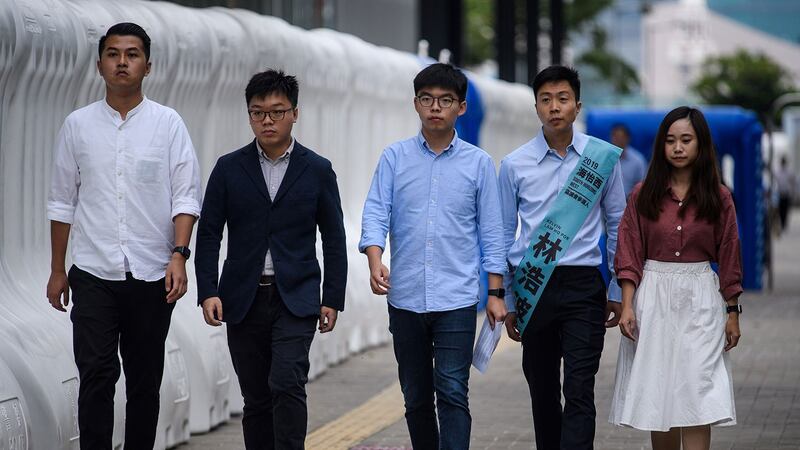 2019年10月29日，香港众志秘书长黄之锋（C）与林浩波（右2）一起抵达香港立法会外的媒体发表讲话。（法新社）