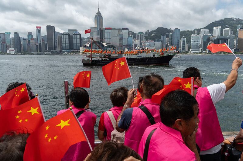 资料照：2024年7月1日，民众在香港挥舞中国国旗。（美联社）