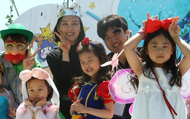 어린이날 서울 광진구 능동로 분수광장에서 어린이들이 엄마, 아빠와 함께 가면무도회를 하며 즐거워하고 있다.