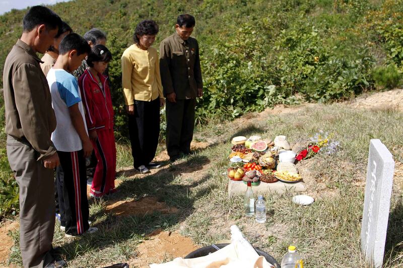추석을 맞아 평양 령송구에 있는 조상의 무덤을 찾아 절하고 있는 북한 주민들