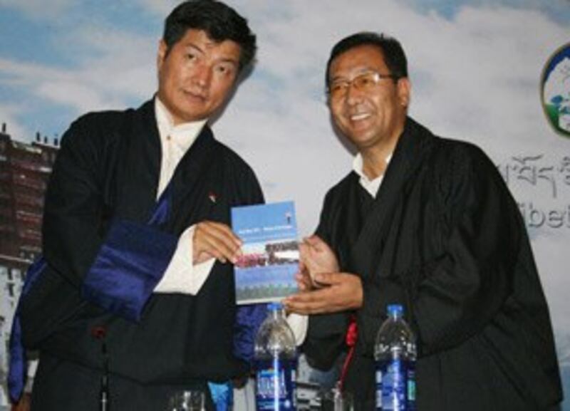 图片： 洛桑森格（左）为英译书籍《2011铁兔年---抗暴的火焰》揭幕。 （记者丹珍拍摄）