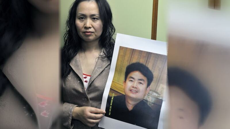 资料图片：前六四学运领袖周勇军的女友张月卫手持周勇军的照片。（法新社） 　　