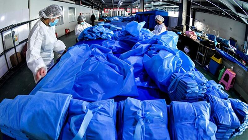 2020年1月27日，新疆乌鲁木齐市一家医疗设备制造商厂的工人在生产防护服和口罩的生产线上劳动。（路透社）