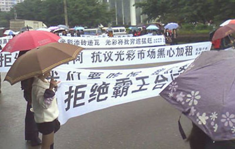 2012年10月15日,重慶光彩市場近百不滿加租商戶手持橫額,於馬路中央遊行抗議。(商場店舖職員陳小姐提供)