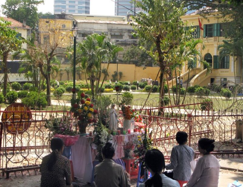 Một nhóm người Công giáo cầu nguyện bên ngoài một khu công viên bị hàng rào quây để xây dựng trên đất tranh chấp với nhà thờ hôm 23/9/2008 ở Hà Nội 