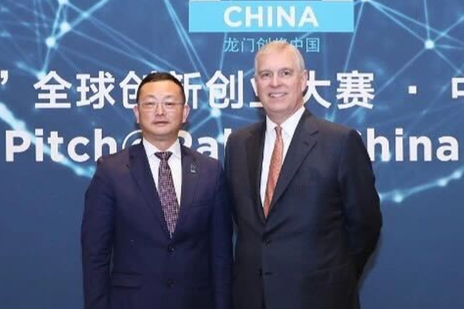Britain's Prince Andrew, right, stands with Yang Tengbo in an image shown at the 