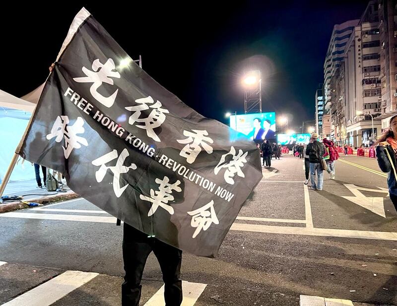 流亡港人赴湯（湯偉雄）帶「光時」旗到現場。（淳音攝）