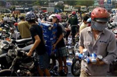 Hình ảnh người dân cướp bia khi chiếc xe tải chở bia bị lật tại vòng xoay Tam Hiệp, Biên Hòa vào chiều ngày 4 tháng 12 năm 2013 làm 1.500 thùng bia Tiger bị đổ xuống đường. Photo courtesy of Nguyễn Vĩnh Blog.