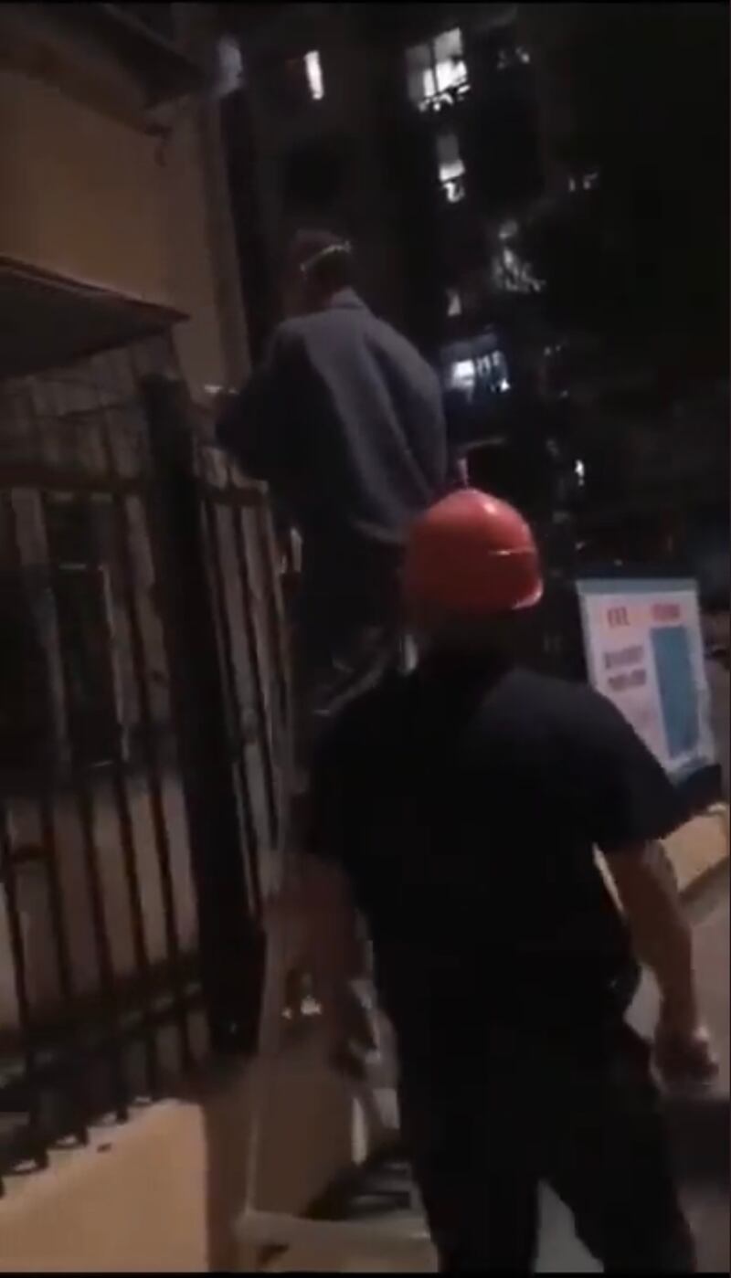 工程人員在隔離社區外牆拉起電網。(影片截圖)