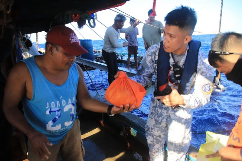 海岸防衛隊人員向漁民送上物資。（菲律賓海岸防衛隊圖片）
