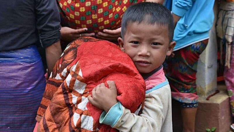 A young boy carries a blanket while fleeing to the town of Kutkai amid fighting between Myanmar forces and rebel ethnic armies in northern Shan state, Sept. 2, 2019.