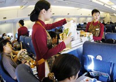 Các tiếp viên hàng không đang phục vụ bữa ăn cho khách. Photo courtesy of yeudulich.vn