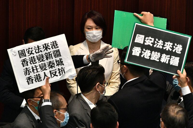 2020年5月22日,香港立法会泛民主派议员在内务委员会的一个会议期间举牌抗议北京强推“港版国安法”,他们被保安阻拦。(法新社)