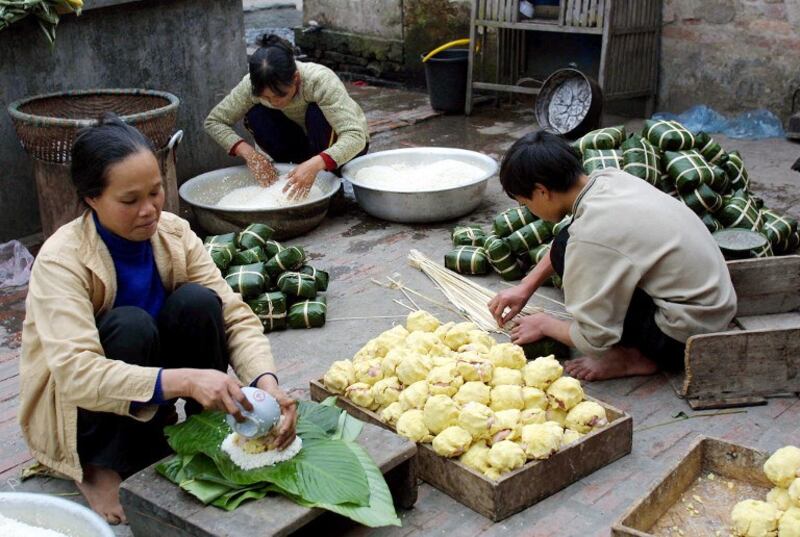 Hình minh họa. Một gia đình đang gói bánh chưng cho Tết ở ngoại thành Hà Nội hôm 7/2/2002