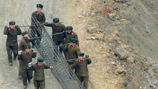 북한군인들이 평양시내 공동주택건설현장에서 철구조물을 운반하고 있다. 