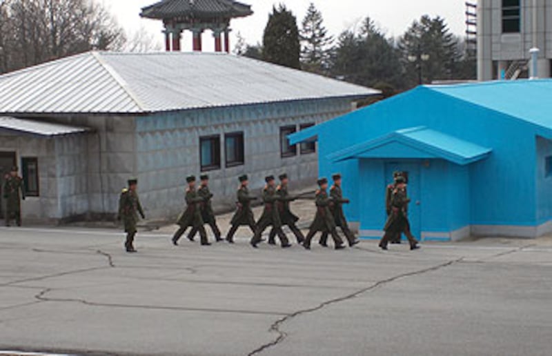 圖片7:板門店是屬於開城的一條村落,其位置就在三八線上,1953年的《朝鮮停戰協定》就是在此簽訂,因此板門店和德國的柏林牆一樣,被視為是冷戰時期的象徵。板門店現在仍然是軍隊鎮守的重點。目前,這裡的軍人如常出操站崗,但就絕對禁止任何人對他們拍攝。就在他們身後,可見一棟棟現代化建築物,這些建築屬於南韓的前線哨站。
