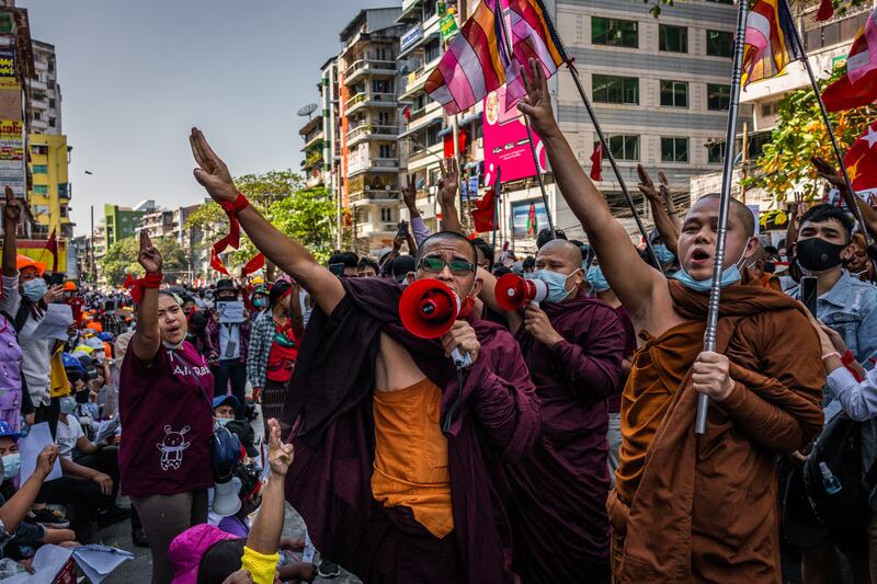 Buddhist monks shout slogans and make three-finger salutes during a protest on February 10, 2021 in Yangon, Myanmar.