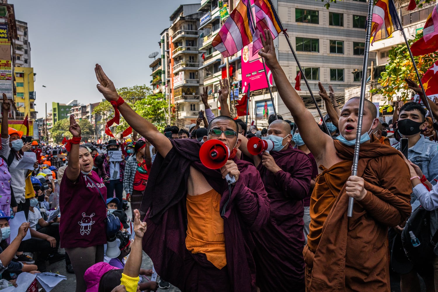 Buddhist monks shout slogans and make three-finger salutes during a protest on February 10, 2021 in Yangon, Myanmar.