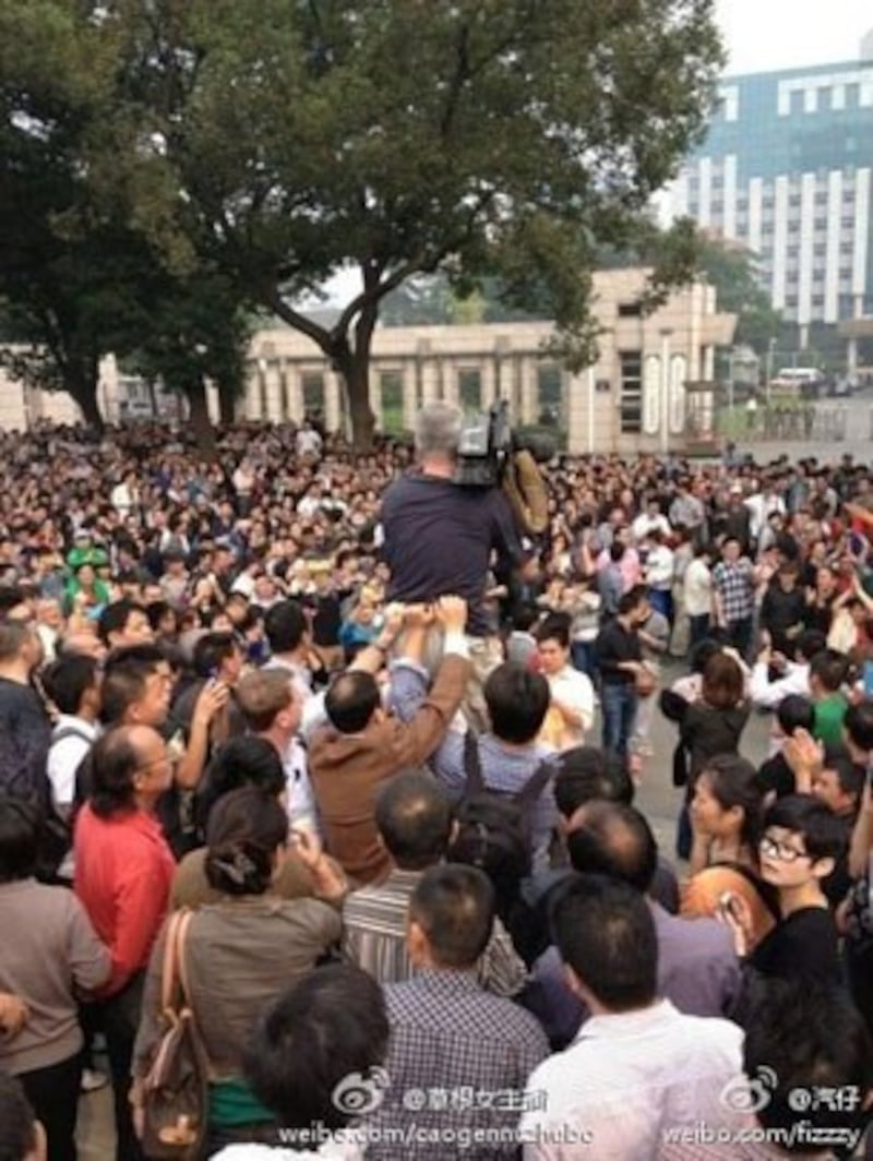 图片：群众不遗余力保护外国记者！特别是他手上的设备。（中国茉莉花革命网）