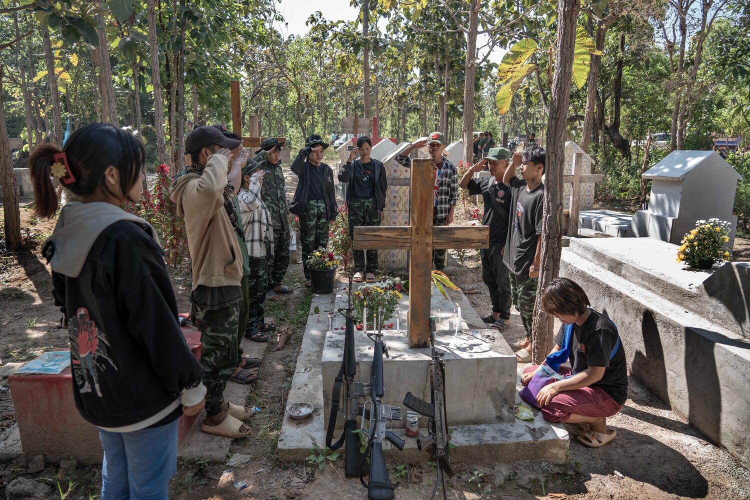 PDF fighters salute at a grave of a fallen fighter at a martyrs cemetery in Demoso, Kayah state, Myanmar, Nov. 2, 2024. (RFA)