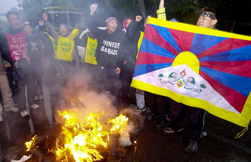 A Tibetan demonstrator displays a Tibetan flag as they protest Chinese Premier Zhu Rongji near the Chinese embassy in New Delhi, Jan. 15, 2002.