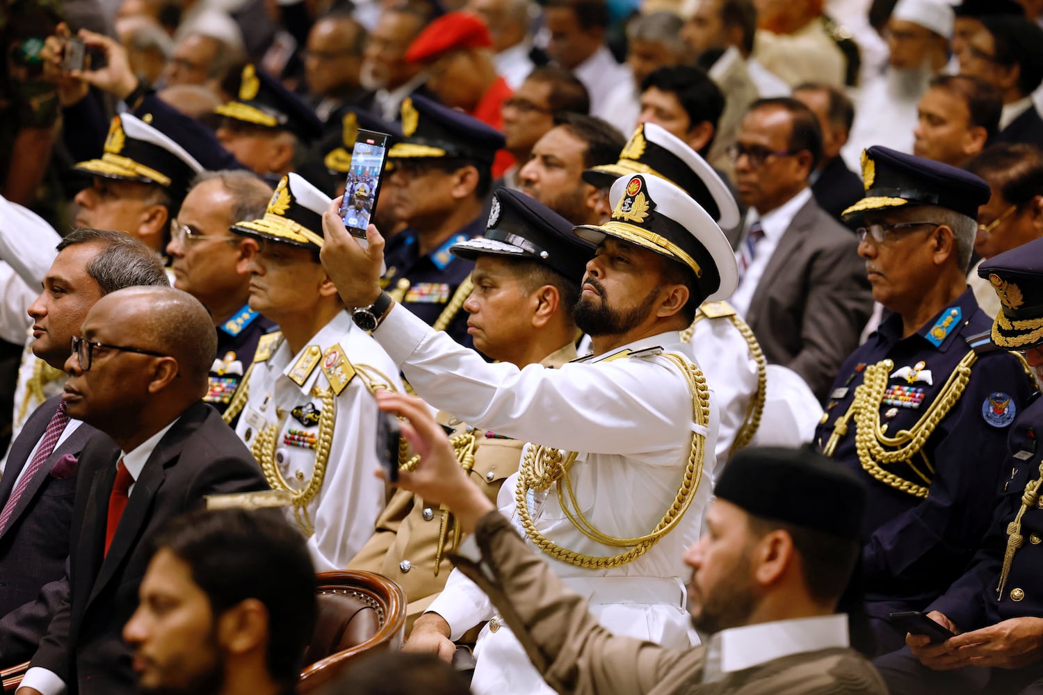 A member of Bangladesh Navy takes a selfie while attending the oath taking ceremony of the interim government, in Dhaka, Aug. 8, 2024. (Mohammad Ponir Hossain/Reuters)