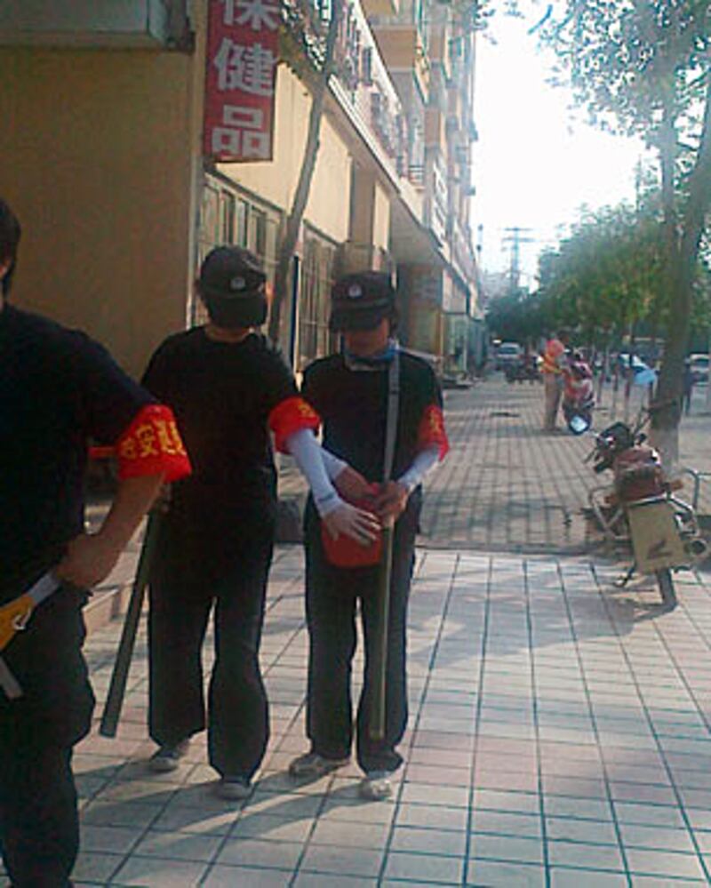 7.5騷亂三週年,新巿區兩名女治安巡邏隊員手持木棍執勤。(照片由居民提供、攝於2012年7月5日)