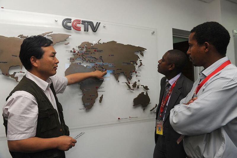 2012 年 6 月 12 日,中央电视台 (CCTV) 非洲总编辑(左)向当地记者展示了CCTV如何在非洲不同地区扩张。(法新社)