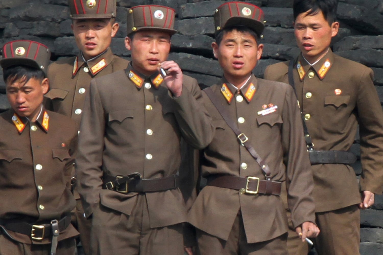 North Korean soldiers scrounge for cigarette butts