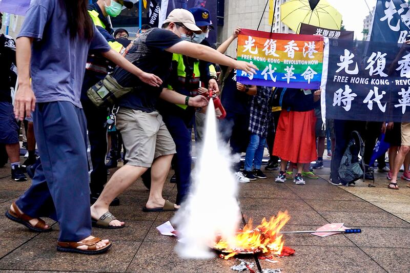民眾焚燒五星旗被警員以滅火器撲滅。（淳音 攝）
