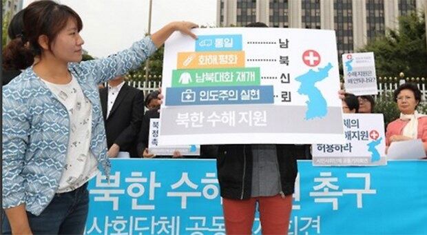 26일 오전 정부서울청사 앞에서 열린 '정부의 북한 수해지원촉구 시민사회단체 공동기자회견'에서 참석자들이 남북신뢰 쌓기 퍼포먼스하고 있다.