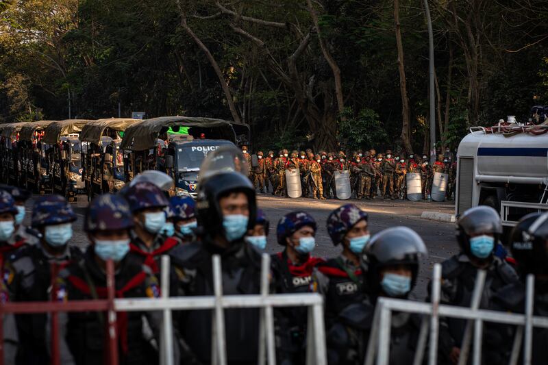 Military soldiers stand behind a line of riot police during a protest on February 9, 2021 in Yangon, Myanmar.