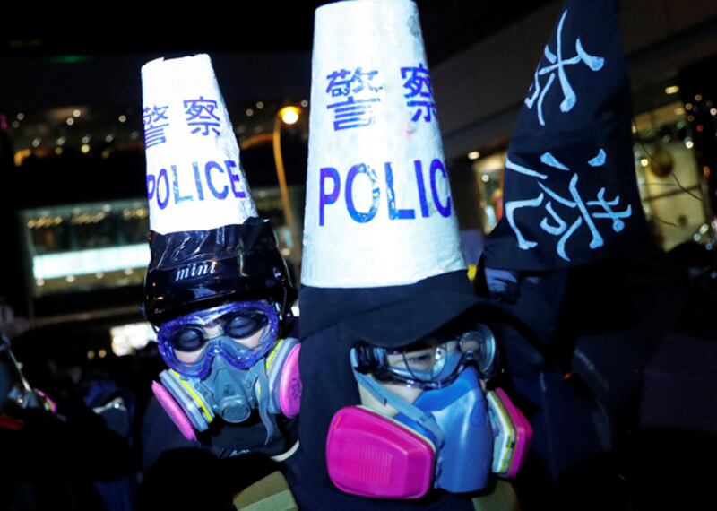 遊行人士戴上面具諷刺警方暴力執法。（路透社）