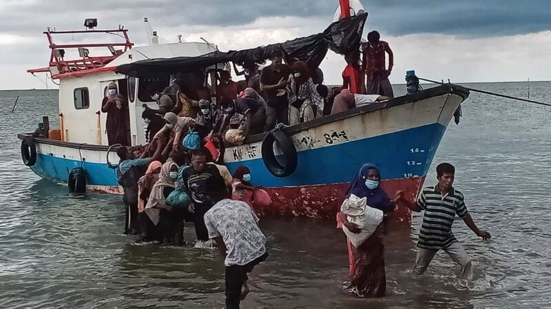 Rohingya women are helped ashore in North Aceh, Indonesia, June 25, 2020.