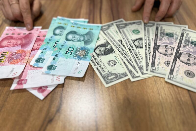 2023년 5월 3일 찍힌 이 사진에서 2018년 탈북한 한 탈북민이 중국 위안화 지폐와 중국 달러 앞에서 북한 내 외화와 원화가 어떻게 사용되는지 설명하고 있다.