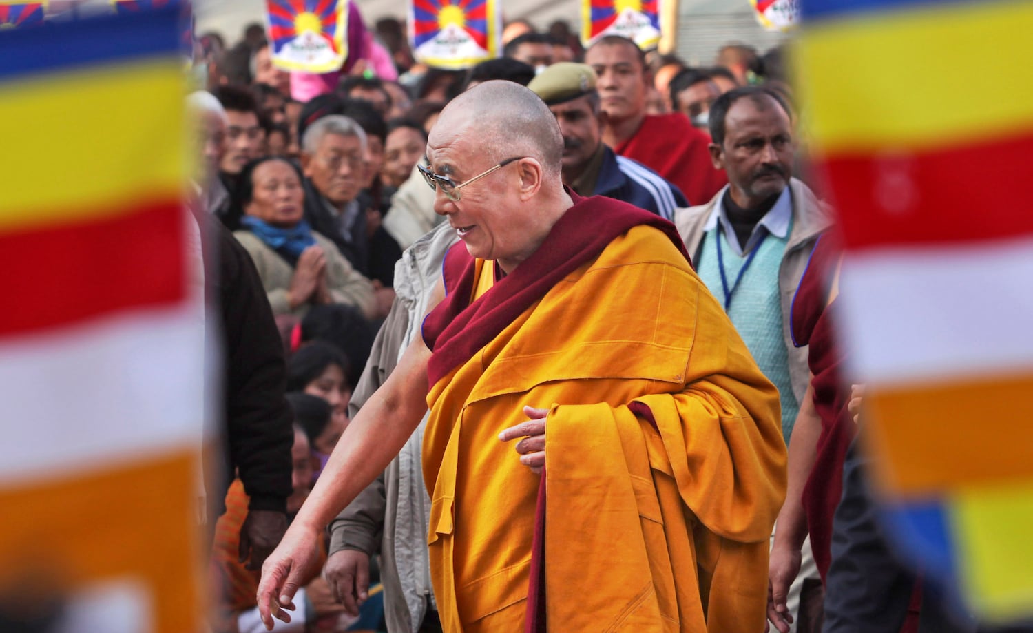 Tibetan spiritual leader the Dalai Lama walks past devotees as he prepares to begin a series of lectures at Mahabodhi temple in Bodh Gaya, India, Jan. 7, 2010.