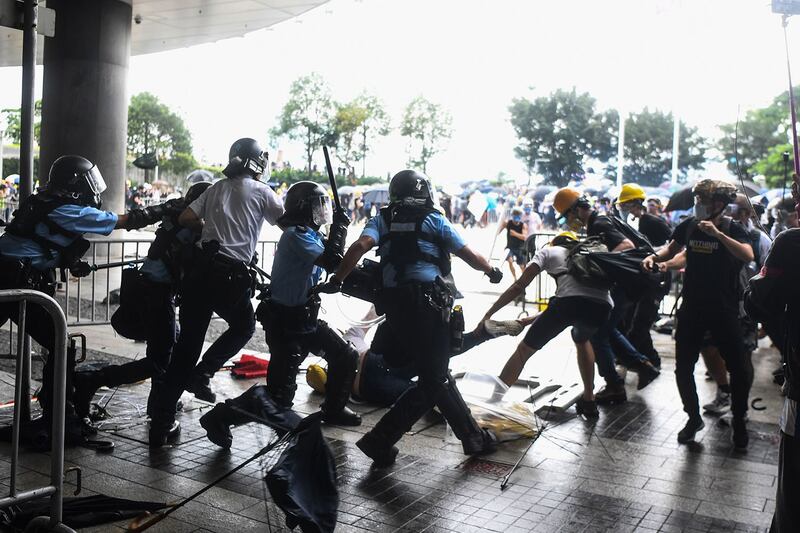 2019年6月12日,香港市民反《逃犯条例》示威活动中,多名防暴警察挥舞警棍殴打一名示威男子。(法新社)