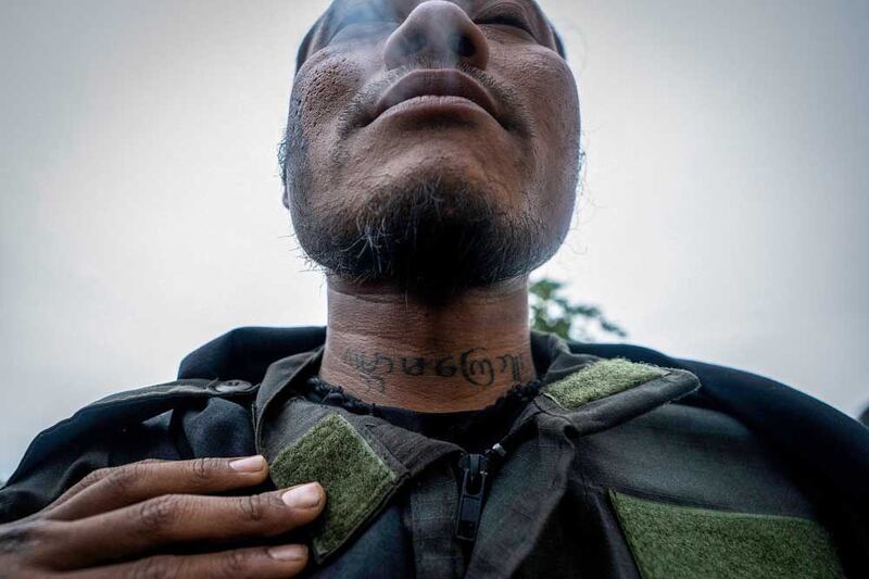 A KPDF member shows off his neck tattoo that reads, "We will never forget and forgive till the end of the world." (AFP)