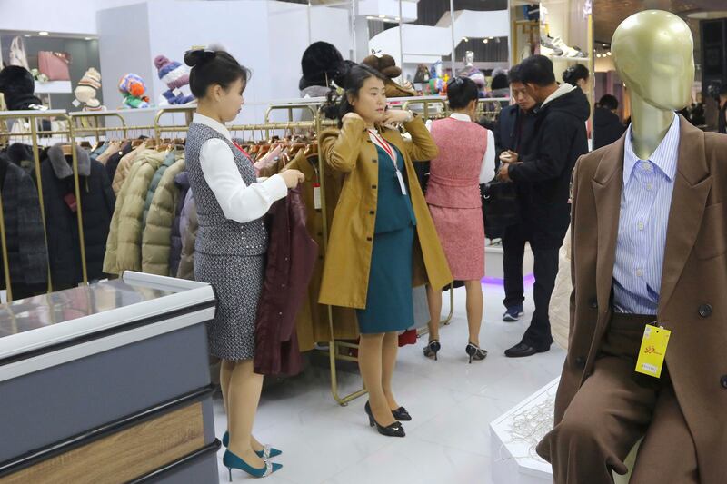 의류 전시회에서 옷을 입어보고 있는 북한 여성