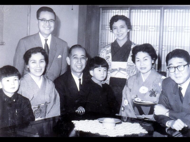 安倍晋三(前排右三)坐在他的祖父和时任日本首相岸信介的腿上,而他的父亲安倍晋太郎(前排右)和母亲洋子(后排右)和他的长辈兄弟。(美联社)