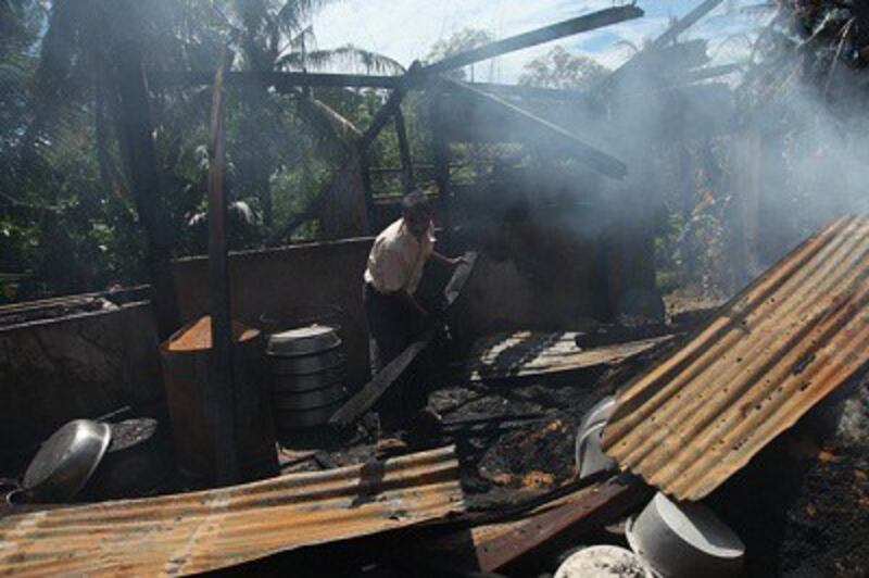 A Muslim man inspects the burnt area of a vandalized building in Thabyuchine village in Thandwe, Oct. 3, 2013. Photo credit: RFA.